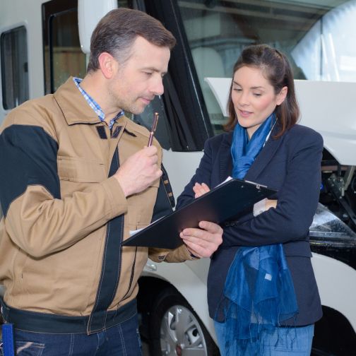Ein Mann und eine Frau stehen vor einem Wohnmobil