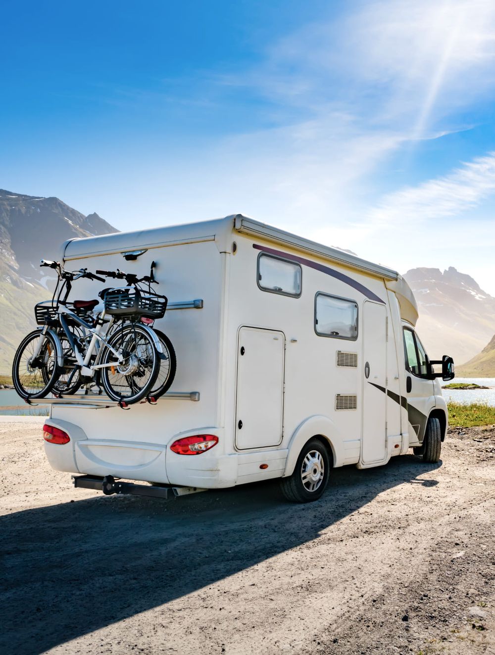 Ein weißer Wohnwagen mit einem Fahrradträger auf der Rückseite